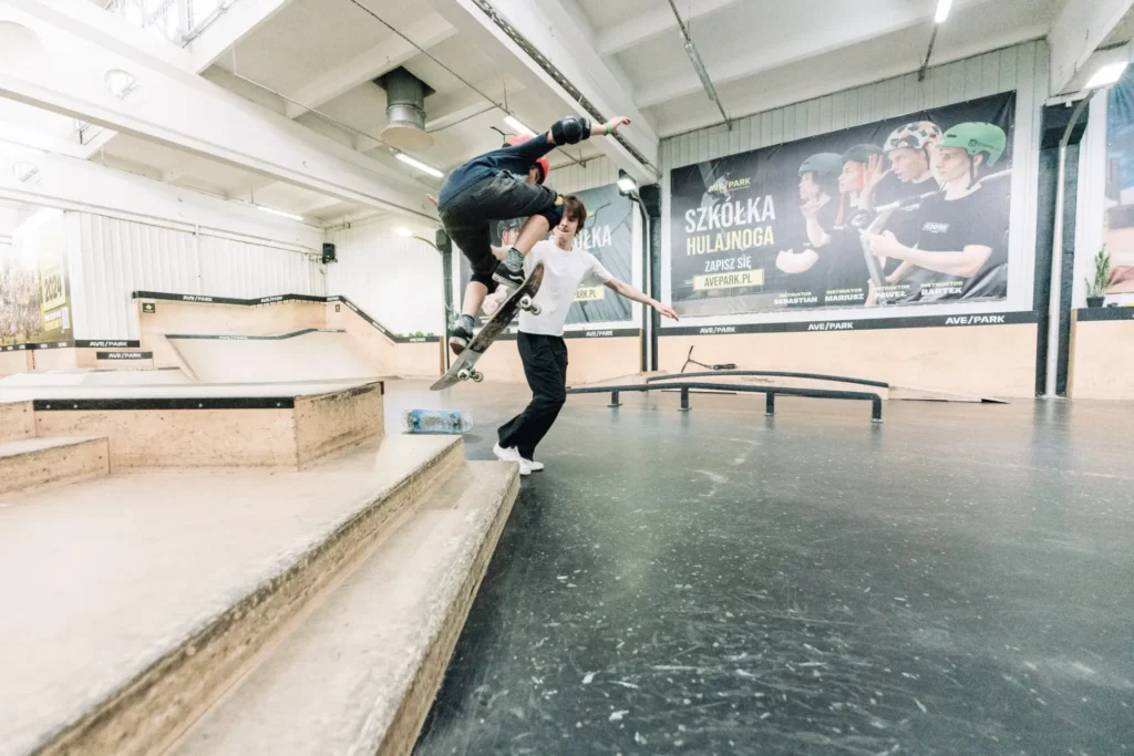 Młody skater ćwiczy na przeszkodzie w hali Ave Park